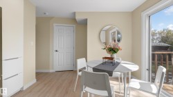 Dining area featuring wood-finish flooring, light-toned walls, and a sliding glass door providing exterior access - 