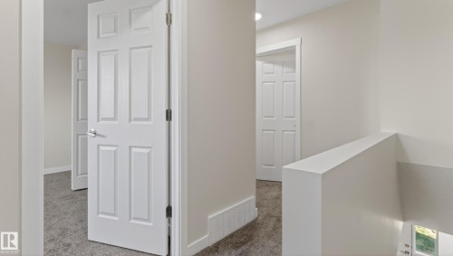 Upper-level hallway featuring neutral wall paint, white six-panel doors, and gray carpet flooring - 14125 30 Street, Edmonton, AB - Indoor Photo Showing Other Room