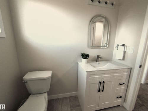 Bathroom featuring a contemporary vanity with white cabinetry and black hardware - 14125 30 Street, Edmonton, AB - Indoor Photo Showing Bathroom