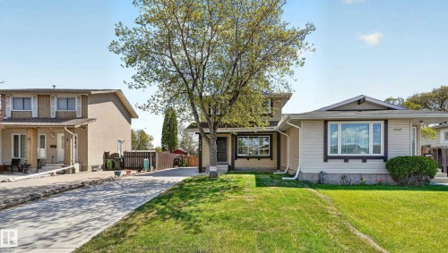 Two-story residence featuring a mature front yard tree, concrete driveway, and a front lawn - 14125 30 Street, Edmonton, AB - Outdoor