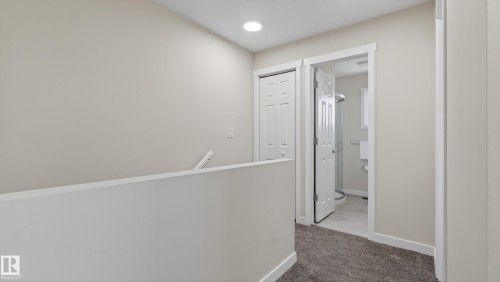 Carpeted hallway with light neutral wall paint and white trim, featuring a recessed ceiling light - 14125 30 Street, Edmonton, AB - Indoor Photo Showing Other Room