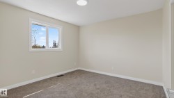 Bright room with neutral wall paint, gray carpet flooring, white trim, a double-pane window, and a flush-mount ceiling light - 