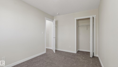 Room featuring neutral-toned walls, grey carpet, white trim, and a white interior door - 14125 30 Street, Edmonton, AB - Indoor Photo Showing Other Room