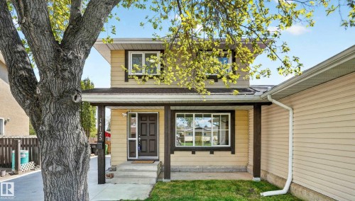 Two-story residence featuring light yellow siding with dark trim accents - 14125 30 Street, Edmonton, AB - Outdoor