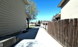 Concrete pathway bordered by a wooden privacy fence - 