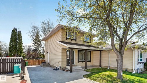 Two-story residence featuring light beige siding and dark trim accents - 14125 30 Street, Edmonton, AB - Outdoor