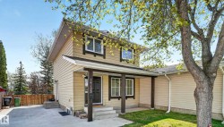 Two-story exterior with light-colored siding, dark trim accents, and a covered porch entry - 