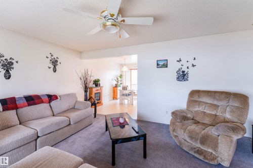 Spacious living area featuring light-toned walls, a white ceiling, and a ceiling fan with integrated lighting - 13231 74 Street, Edmonton, AB - Indoor Photo Showing Living Room