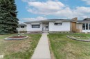White exterior siding featuring a front entrance with a storm door, an adjacent window with an awning, and a dedicated sidewalk leading to the entrance - 13231 74 Street, Edmonton, AB  - Outdoor 