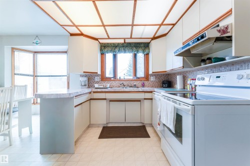 Kitchen with white cabinetry, tile flooring, and a drop ceiling with integrated lighting - 13231 74 Street, Edmonton, AB - Indoor Photo Showing Other Room