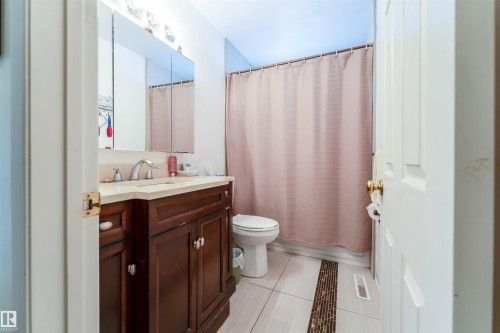 Bathroom featuring a dark wood-finish vanity with a light-toned countertop and an undermount sink - 13231 74 Street, Edmonton, AB - Indoor Photo Showing Bathroom