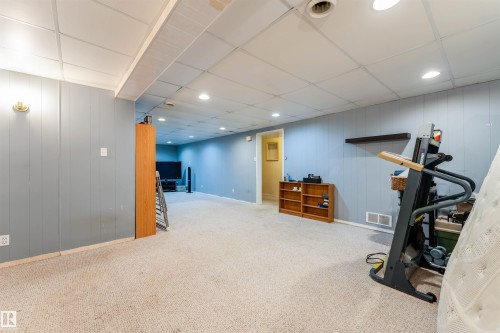 Carpeted room featuring light blue paneled walls, white acoustic tile ceiling, and recessed lighting - 13231 74 Street, Edmonton, AB - Indoor Photo Showing Other Room