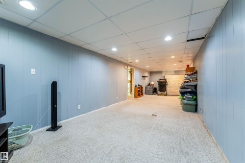 Finished lower level featuring light blue vertical paneling, recessed lighting, and light-toned carpet flooring - 13231 74 Street, Edmonton, AB - Indoor