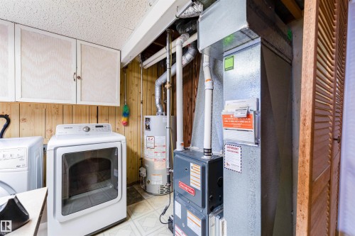 Utility area featuring a water heater, furnace, and a washer and dryer set - 13231 74 Street, Edmonton, AB - Indoor Photo Showing Laundry Room