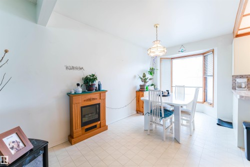 Dining area featuring a bay window, recessed ceiling beam, and light-toned flooring - 13231 74 Street, Edmonton, AB - Indoor Photo Showing Other Room
