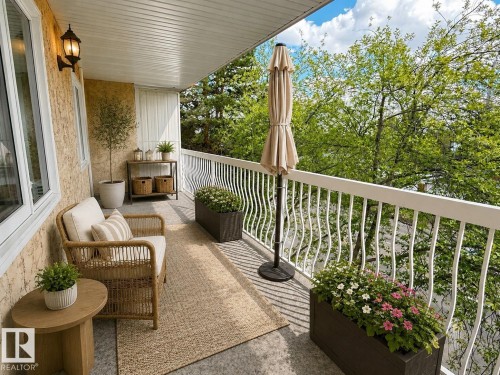 Inviting balcony with a textured stucco exterior, white railings, and a concrete-finish floor - 309 10610 76 Street, Edmonton, AB - Outdoor With Deck Patio Veranda With Exterior