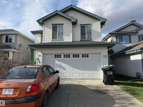 Two-story residence featuring light-toned horizontal siding with dark green trim accents - 8910 7 Avenue, Edmonton, AB - Outdoor