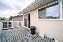 Spacious outdoor deck with white railing, featuring direct access via sliding glass doors and a large window - 