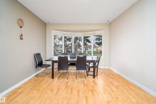 Bright interior featuring a bay window, light wood-finish flooring, and white baseboards - 1771 37 Street, Edmonton, AB - Indoor Photo Showing Dining Room