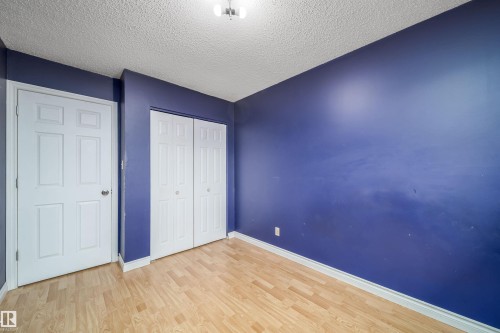 Room featuring wood-finish flooring, vibrant blue walls, and white trim - 1771 37 Street, Edmonton, AB - Indoor Photo Showing Other Room