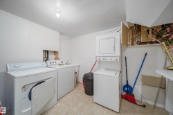Dedicated laundry area featuring tile flooring, white walls, and a utility sink - 
