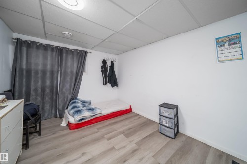 Room featuring light wood-finish flooring, white painted walls, and a drop ceiling with recessed lighting - 1771 37 Street, Edmonton, AB - Indoor