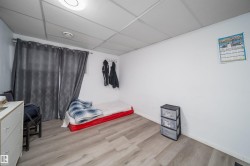 Room featuring light wood-finish flooring, white painted walls, and a drop ceiling with recessed lighting - 