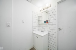 Bathroom vanity featuring a white cabinet, integrated sink, and brushed nickel faucet - 