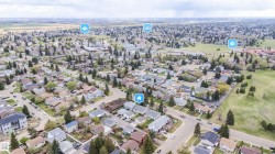 Aerial perspective of a residential neighborhood featuring numerous detached homes with varying rooflines and exterior finishes - 