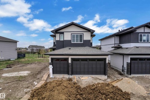 Contemporary exterior featuring a two-tone facade with dark siding and light-colored panels - 12623 44 Street, Edmonton, AB 