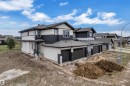 Two-story residence featuring a gray shingled roof, white siding, and dark vertical panel accents - 12623 44 Street, Edmonton, AB 