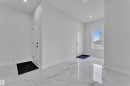 Spacious entryway featuring large format tile flooring, recessed lighting, white trim, and a window with a bright outlook - 12623 44 Street, Edmonton, AB 