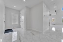 Entry foyer featuring large format tile flooring, recessed lighting, white walls, and a white paneled door - 12623 44 Street, Edmonton, AB 