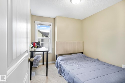 Carpeted room featuring a single window with white trim, neutral wall paint, and a textured ceiling - 30 6075 Schonsee Way, Edmonton, AB - Indoor Photo Showing Bedroom