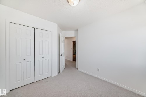 Neutral-toned carpeting extends throughout this room, featuring white walls and baseboards - 2339 28B Ave Avenue, Edmonton, AB - Indoor