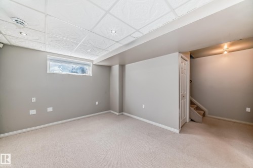 Spacious room featuring neutral carpeting and light gray painted walls - 2339 28B Ave Avenue, Edmonton, AB - Indoor