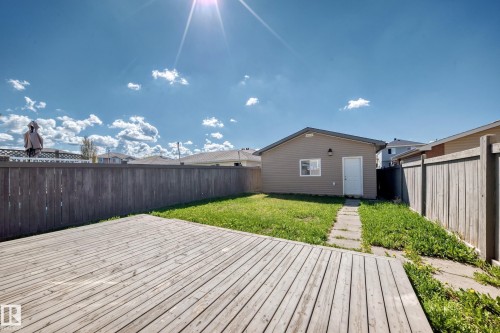 Expansive backyard featuring a wood deck, manicured lawn, and privacy fencing - 2339 28B Ave Avenue, Edmonton, AB - Outdoor