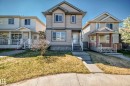 Two-story residential exterior featuring neutral siding, dark trim accents, multiple windows, and a concrete pathway leading to the entry - 2339 28B Ave Avenue, Edmonton, AB  - Outdoor With Deck Patio Veranda With Facade 