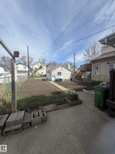 Expansive backyard featuring a partial chain-link fence, a detached auxiliary building, and a concrete pathway - 9630 106 Avenue, Edmonton, AB - Outdoor