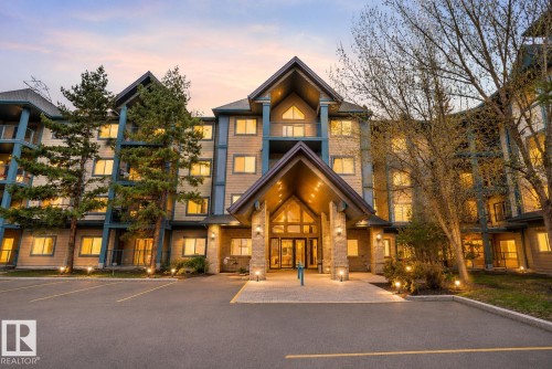 Multi-story building featuring a stone and siding exterior with prominent gabled rooflines, large windows, and individual balconies - 110 2903 Rabbit Hill Road, Edmonton, AB - Outdoor With Facade