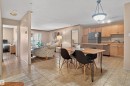 Kitchen and dining area featuring tile flooring, wood-finish cabinetry, a peninsula breakfast bar, and stainless steel appliances - 110 2903 Rabbit Hill Road, Edmonton, AB  - Indoor 