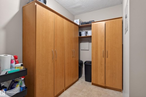 Extensive built-in cabinetry with light wood-finish doors and brushed nickel hardware - 110 2903 Rabbit Hill Road, Edmonton, AB - Indoor Photo Showing Other Room