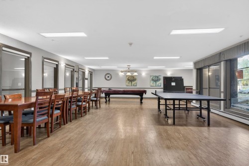 Spacious common area featuring wood-finish flooring, recessed lighting, and multiple windows - 110 2903 Rabbit Hill Road, Edmonton, AB - Indoor Photo Showing Dining Room
