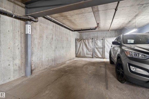 Concrete parking space with exposed concrete walls and ceiling - 110 2903 Rabbit Hill Road, Edmonton, AB - Indoor Photo Showing Garage