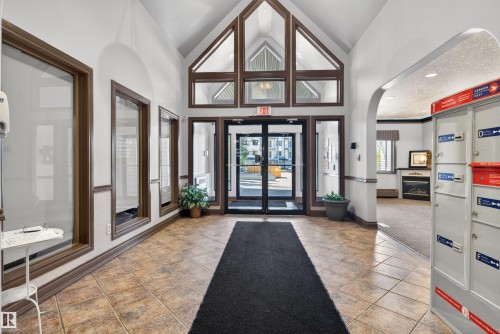 Vaulted entry with tall windows and transom detailing - 110 2903 Rabbit Hill Road, Edmonton, AB - Indoor Photo Showing Other Room
