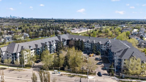 Multi-level residential building featuring dark shingle roofing and light-colored exterior siding - 110 2903 Rabbit Hill Road, Edmonton, AB - Outdoor With View