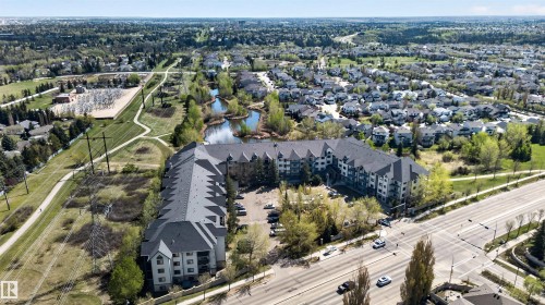 Multi-story residential building with grey roofing and light-colored siding - 110 2903 Rabbit Hill Road, Edmonton, AB - Outdoor With View