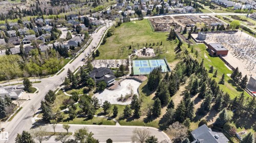 Aerial perspective showcasing the surrounding residential area and extensive green spaces - 110 2903 Rabbit Hill Road, Edmonton, AB - Outdoor With View