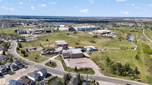 Aerial perspective showcasing a residential community with abundant green spaces - 110 2903 Rabbit Hill Road, Edmonton, AB - Outdoor With View