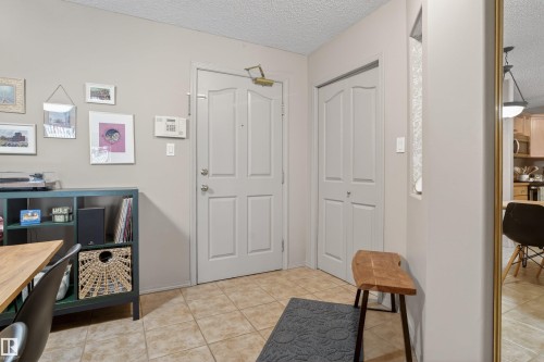 Entryway featuring tile flooring, panel doors, and a built-in closet with bi-fold doors - 110 2903 Rabbit Hill Road, Edmonton, AB - Indoor Photo Showing Other Room